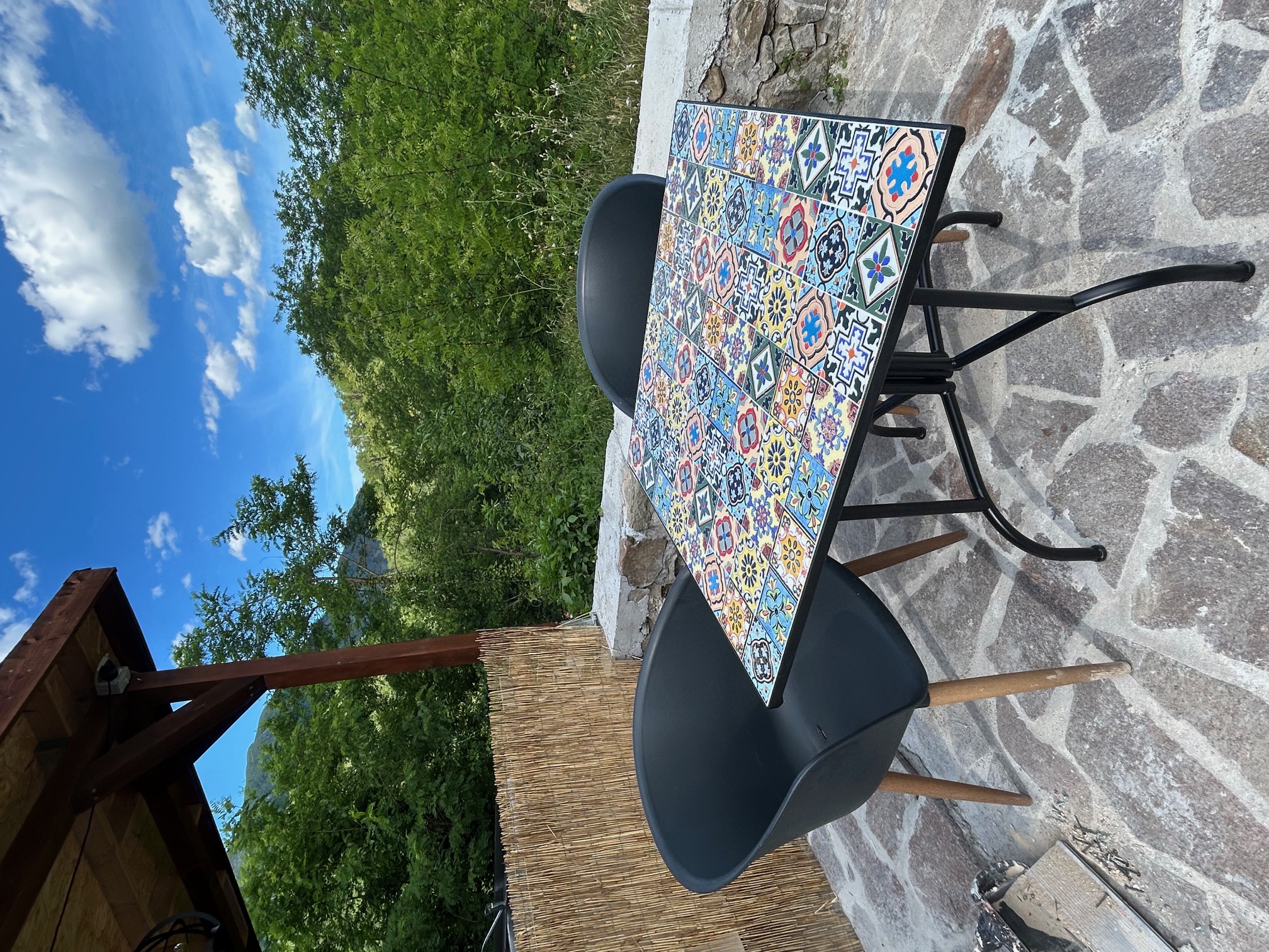 Terras met handgeschilderde tegeltafel en bergzicht